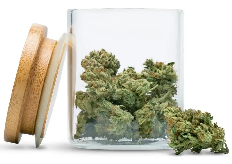 Glass jar with cannabis buds, wooden lid beside it.