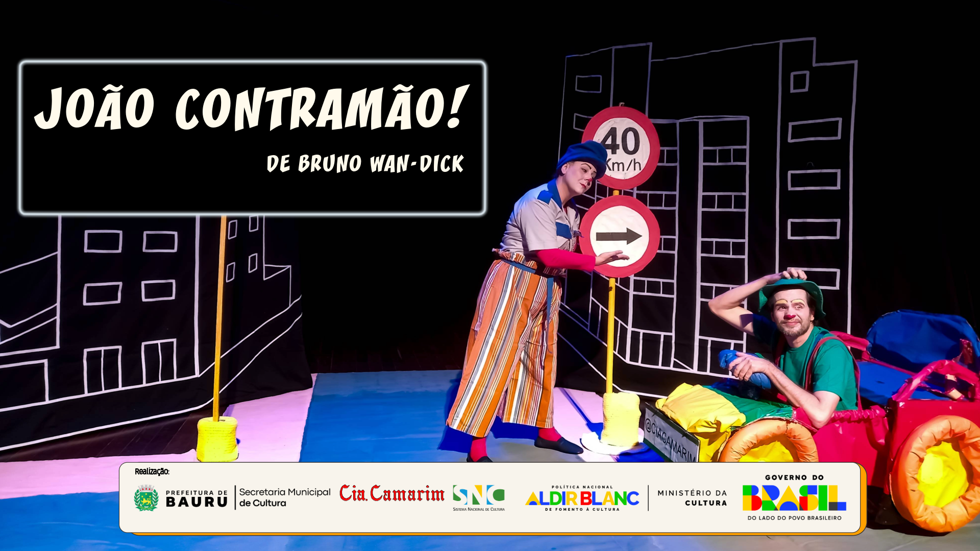 Banner com “João Contratão!” e atores em cena teatral colorida, com placa de trânsito e carro iluminado.