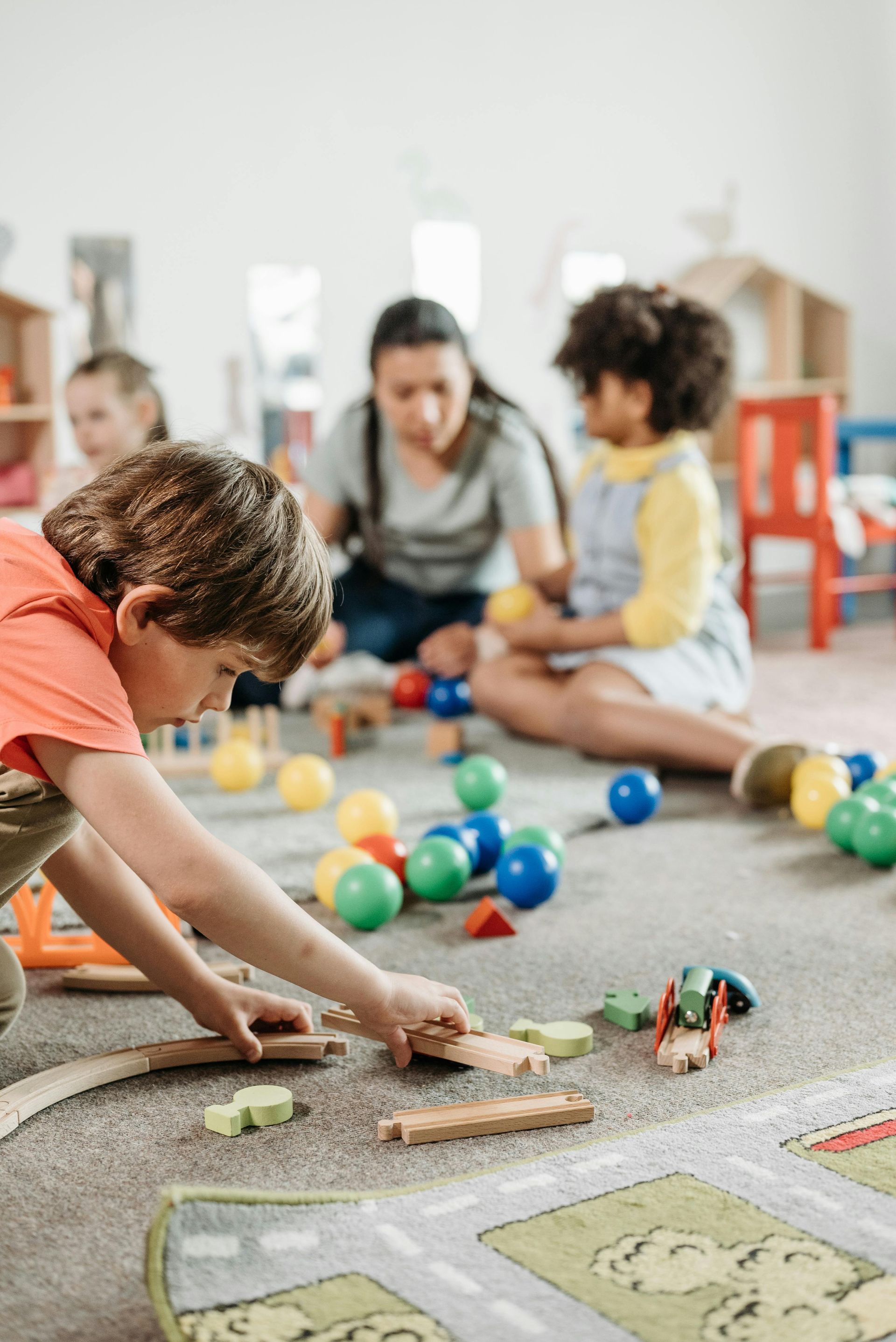 Une enseignante et deux enfants jouent