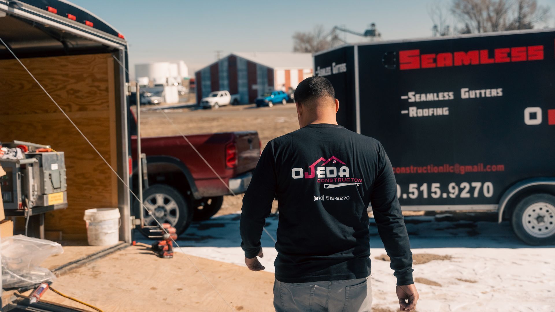 A man is walking towards a truck and trailer.