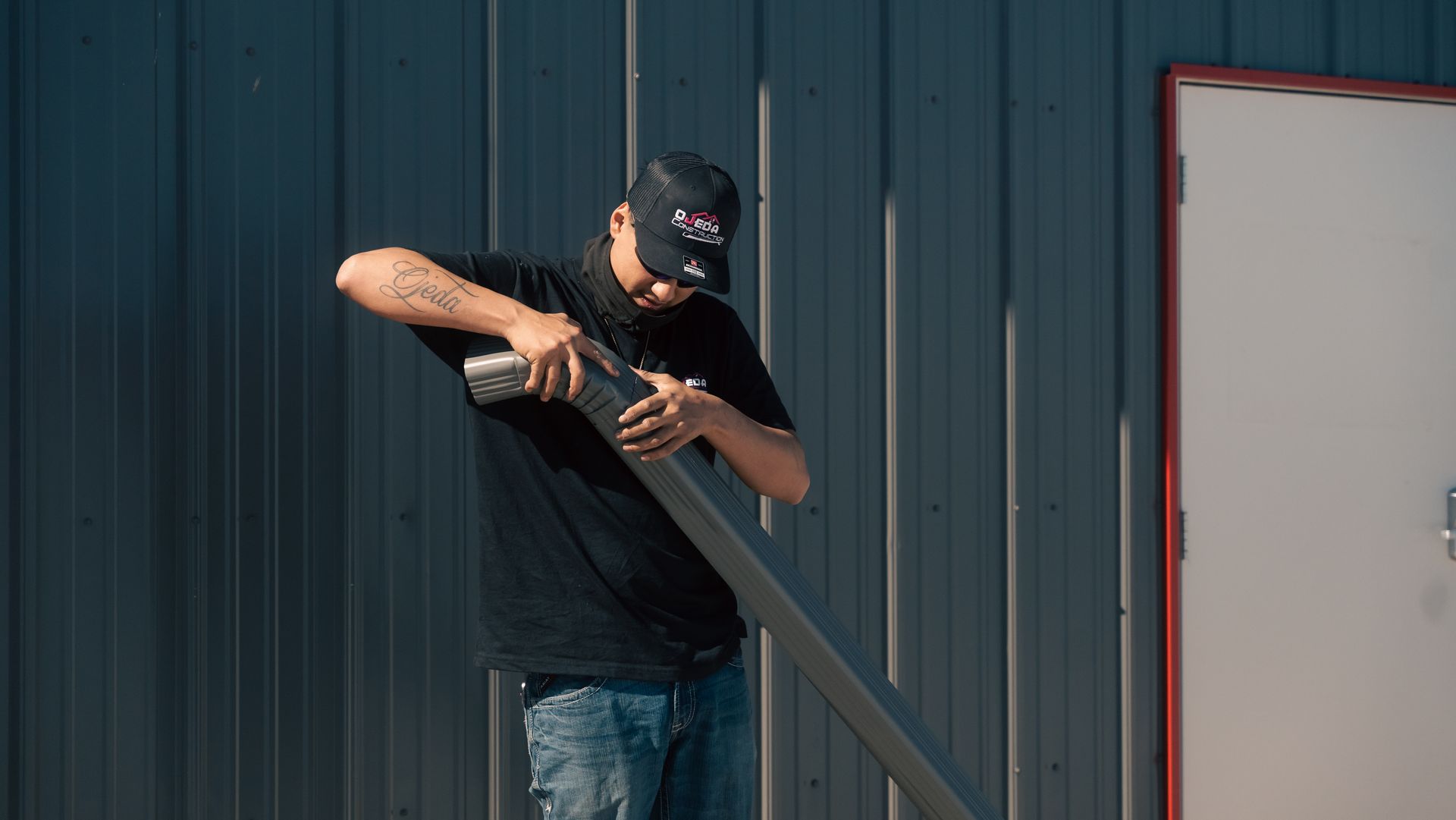 A man is working on a gutter outside of a building.