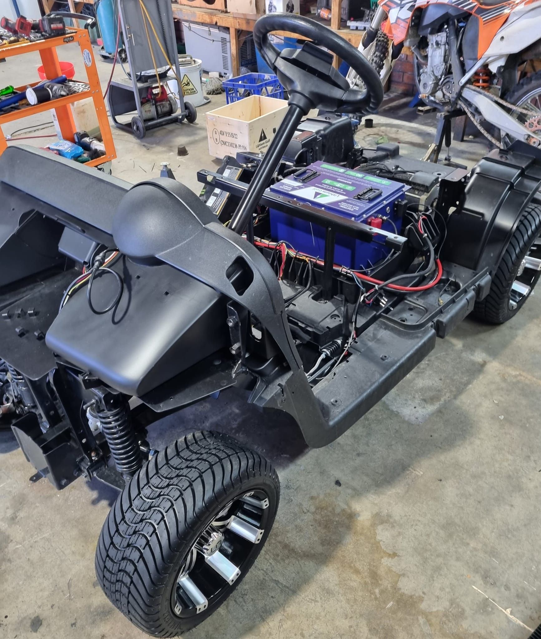 Black Golf Cart Chassis Being Assembled Indoors, With Black Wheels — Orange Auto Electrics in Orange, NSW