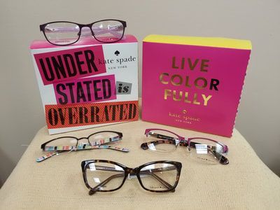 A pair of glasses sitting on top of a table next to a sign that says `` under stated is overrated ''.