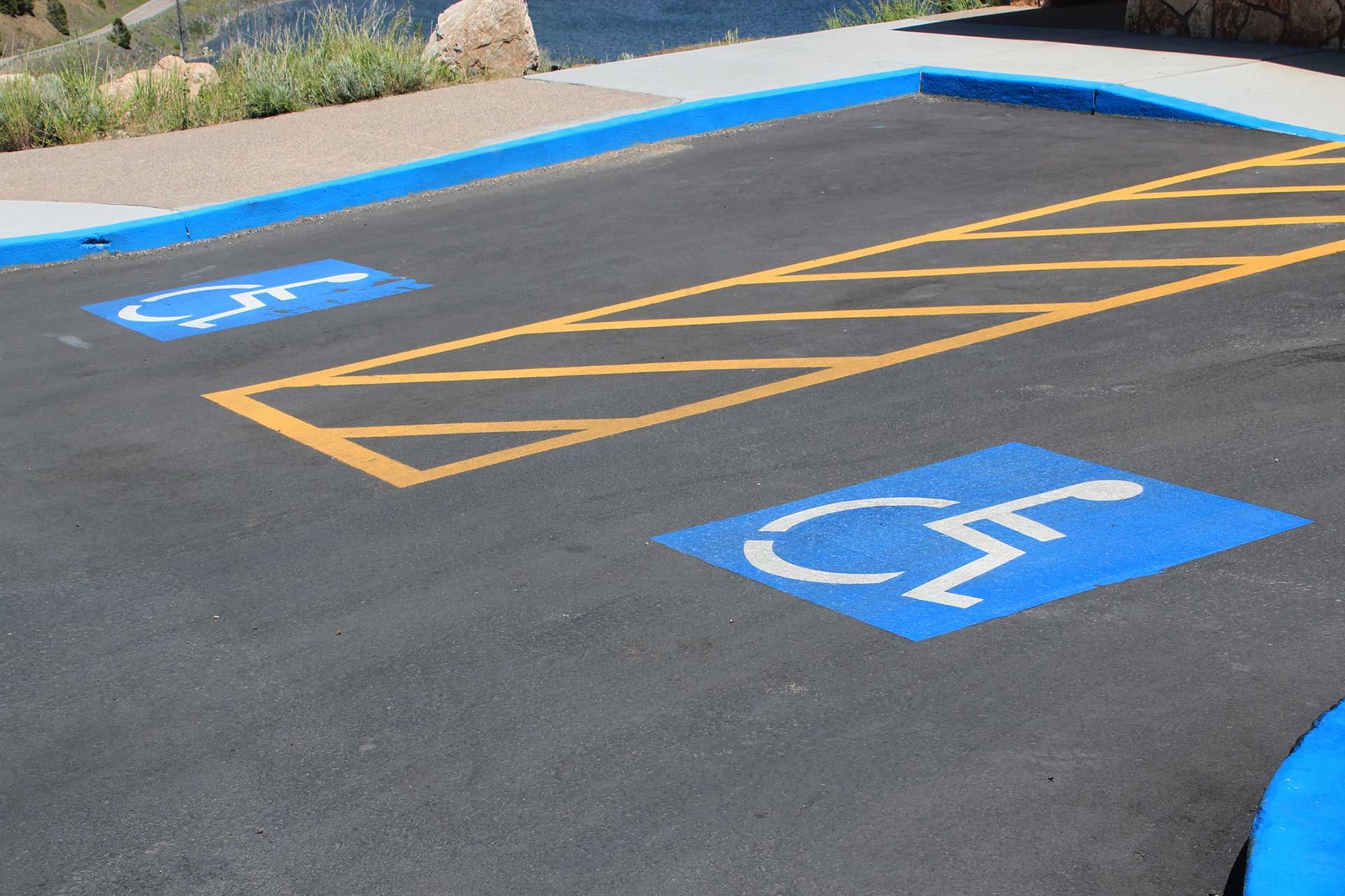 Two blue handicapped parking spaces with white wheelchair symbols on asphalt.