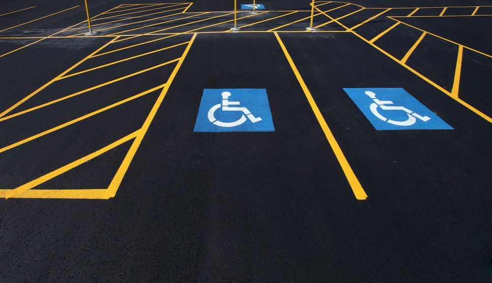 Two handicap parking spaces painted on dark asphalt.
