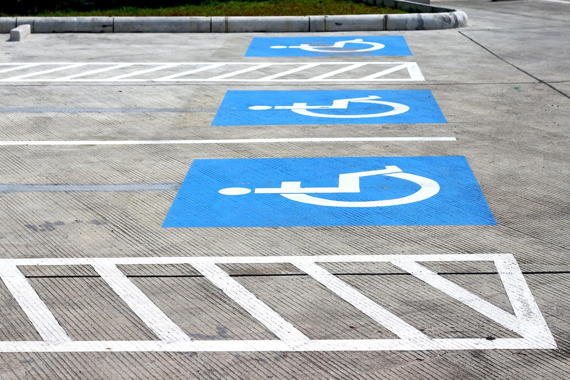 Blue and white handicap parking spaces in a concrete parking lot.