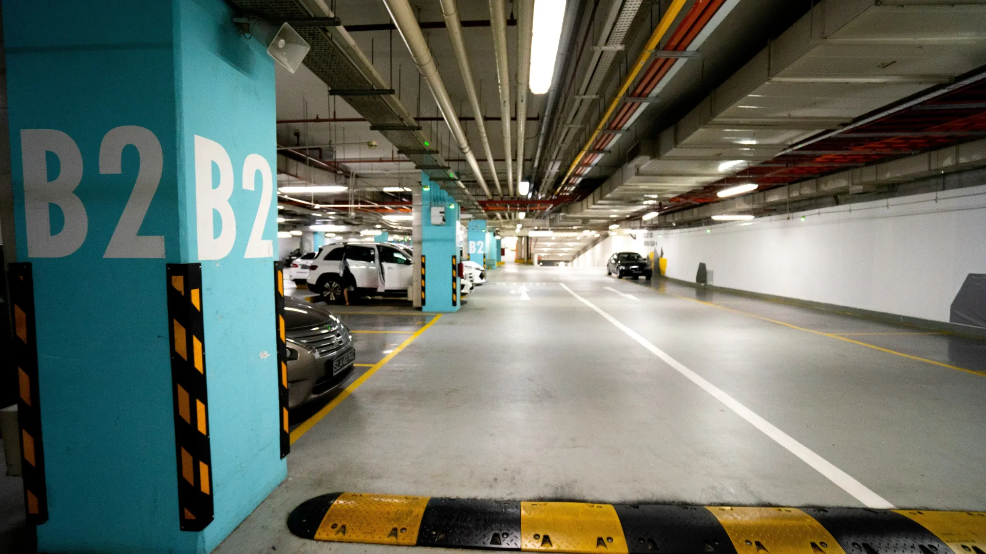 Underground parking garage with blue pillars labeled