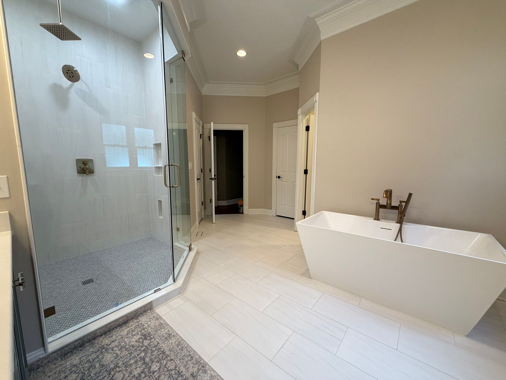Custom bathroom remodel with new tiling, glass shower enclosure, and freestanding tub in Franklin, Tennessee
