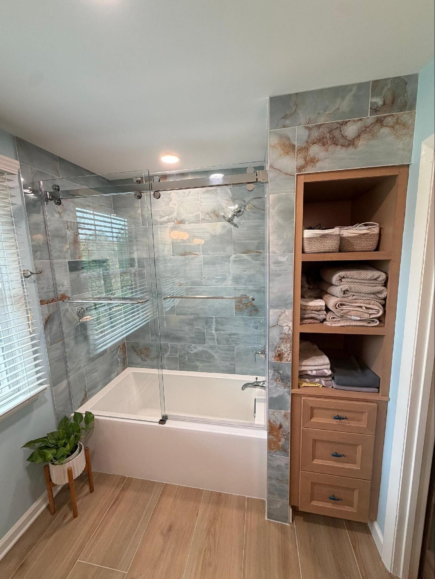 After image of Nashville TN shower remodel with glass sliding shower doors and custom storage