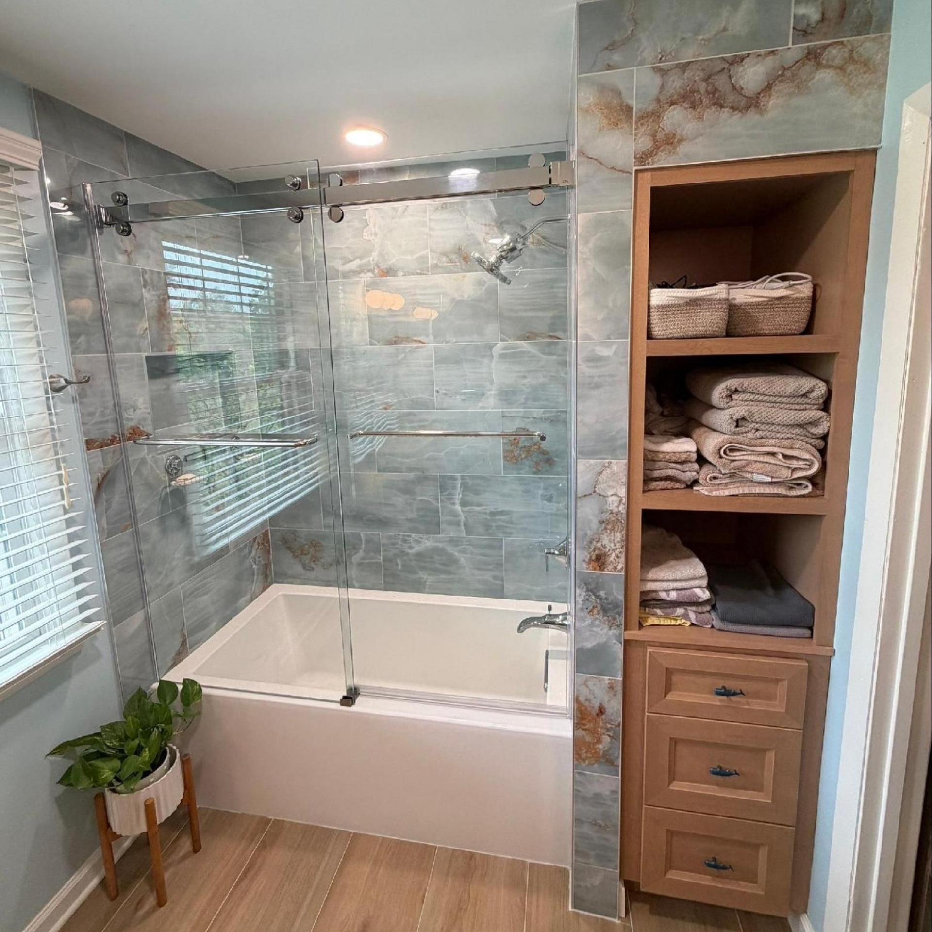 After photo of a Nashville bathroom remodel with improved glass shower doors and custom storage