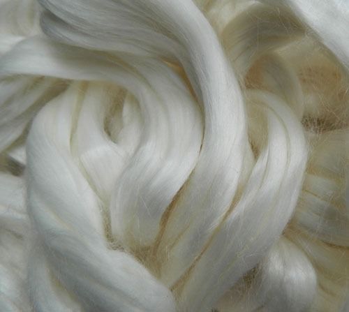 Fibre di seta bianca, strettamente intrecciate e intrecciate, dalla consistenza liscia e lucente.