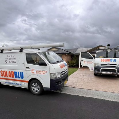 Two Solarblu Service Vans Parked in a Driveway Under Cloudy Skies — Solarblu Pty Ltd In Dapto, NSW