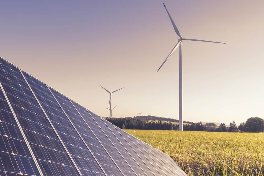 There Are Two Wind Turbines In The Background And A Solar Panel In The Foreground — Solarblu Pty Ltd In Berry, NSW