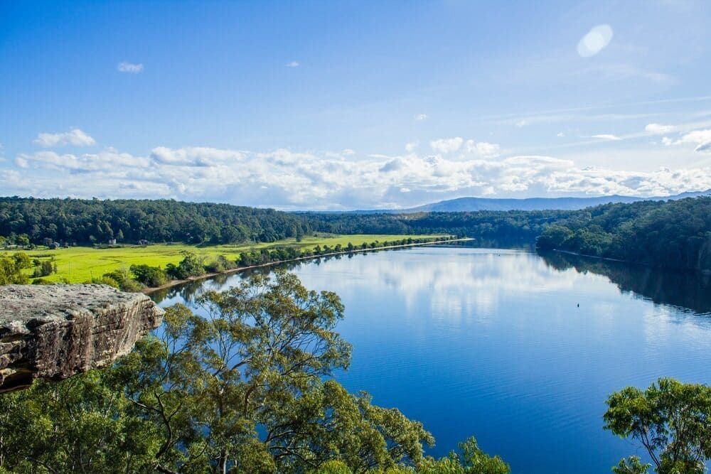 A Large Body Of Water Surrounded By Trees On A Sunny Day — Solarblu Pty Ltd In Nowra, NSW