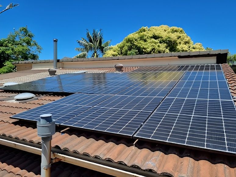 Solar Panels Mounted on a Terracotta Roof Under a Bright Blue Sky — Solarblu Pty Ltd In Dapto, NSW