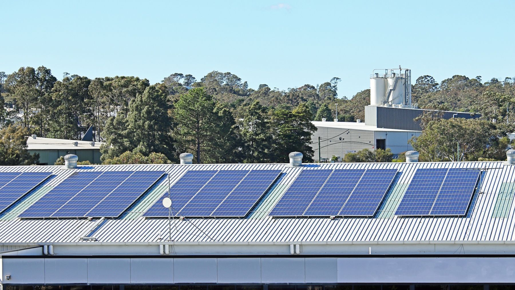 A Row Of Solar Panels With A City Skyline In The Background — Solarblu Pty Ltd In Woonona, NSW