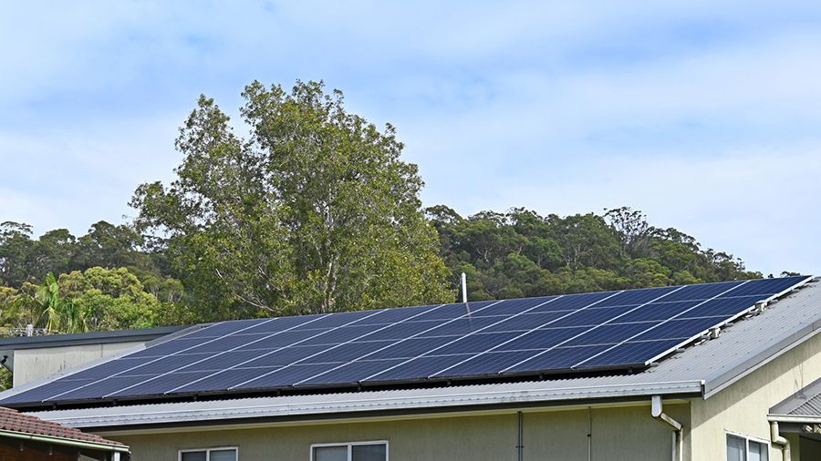 A Beige House With Solar Panels On The Roof — Solarblu Pty Ltd In Dapto, NSW