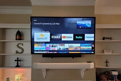 Wall-mounted TV displaying a streaming apps home screen in a cozy living room