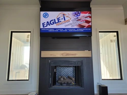 Modern fireplace with a mounted Eagle TV screen above it and narrow windows on either side.