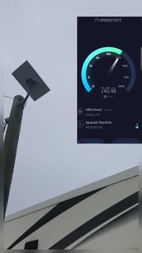 Speed test screen on a phone beside a rooftop satellite dish under a cloudy sky.