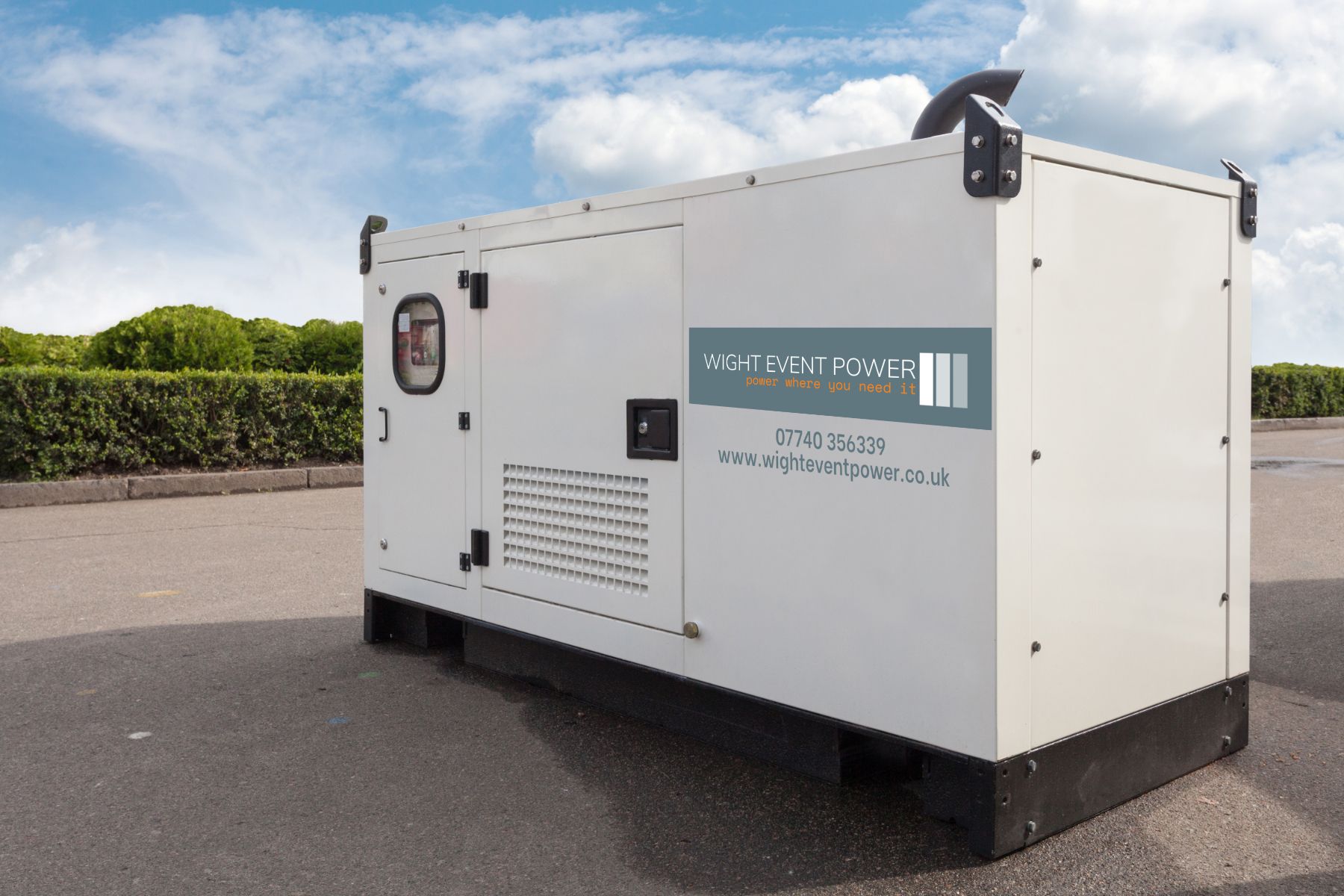 White portable generator unit on pavement, with vents and control panel under a blue sky.
