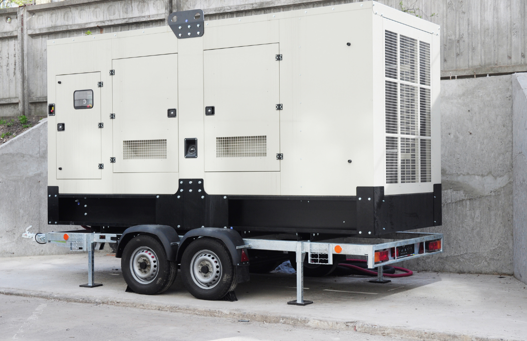 White dual-axle generator trailer parked beside a concrete wall