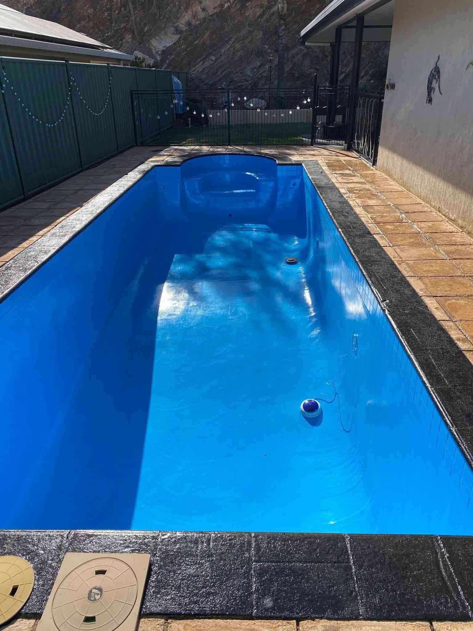 A Large Blue Swimming Pool is Sitting in Front of a House — NHM Painting & Projects in Ciccone, NT