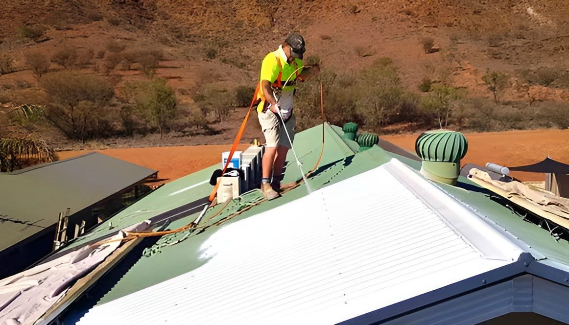 A Man is Painting the Roof of a House  — NHM Painting & Projects Pty Ltd in Ciccone, NT