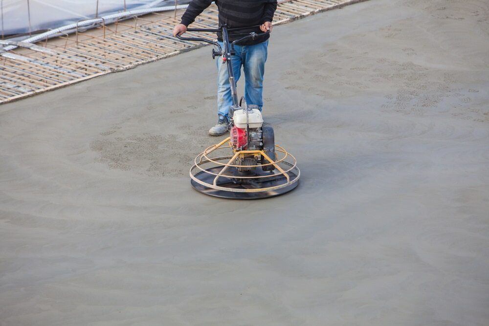 A Man is Using a Machine to Finish Concrete on a Construction Site  — NHM Painting & Projects in Ciccone, NT