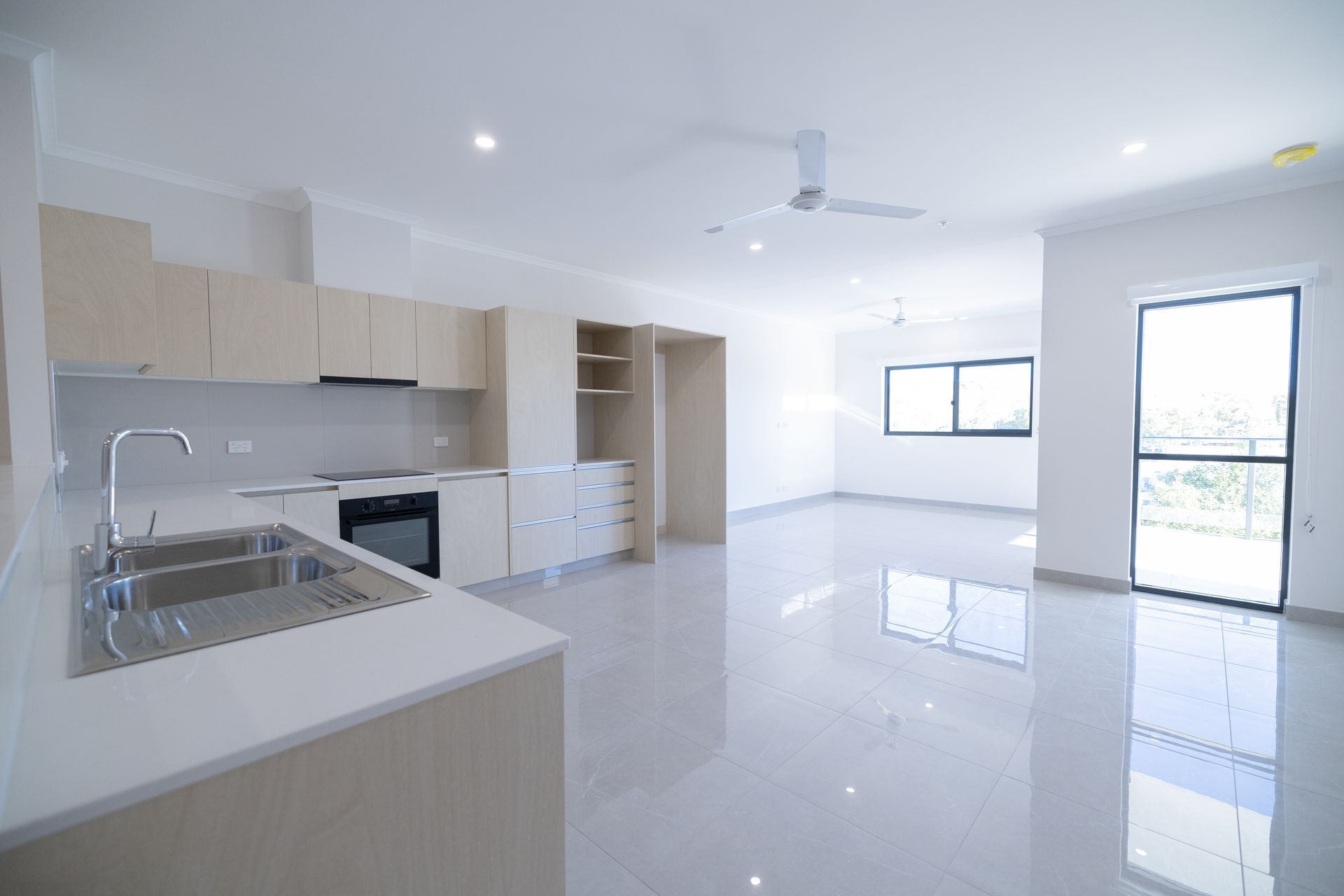 An Empty Kitchen With a Sink and a Ceiling Fan — NHM Painting & Projects in Ciccone, NT