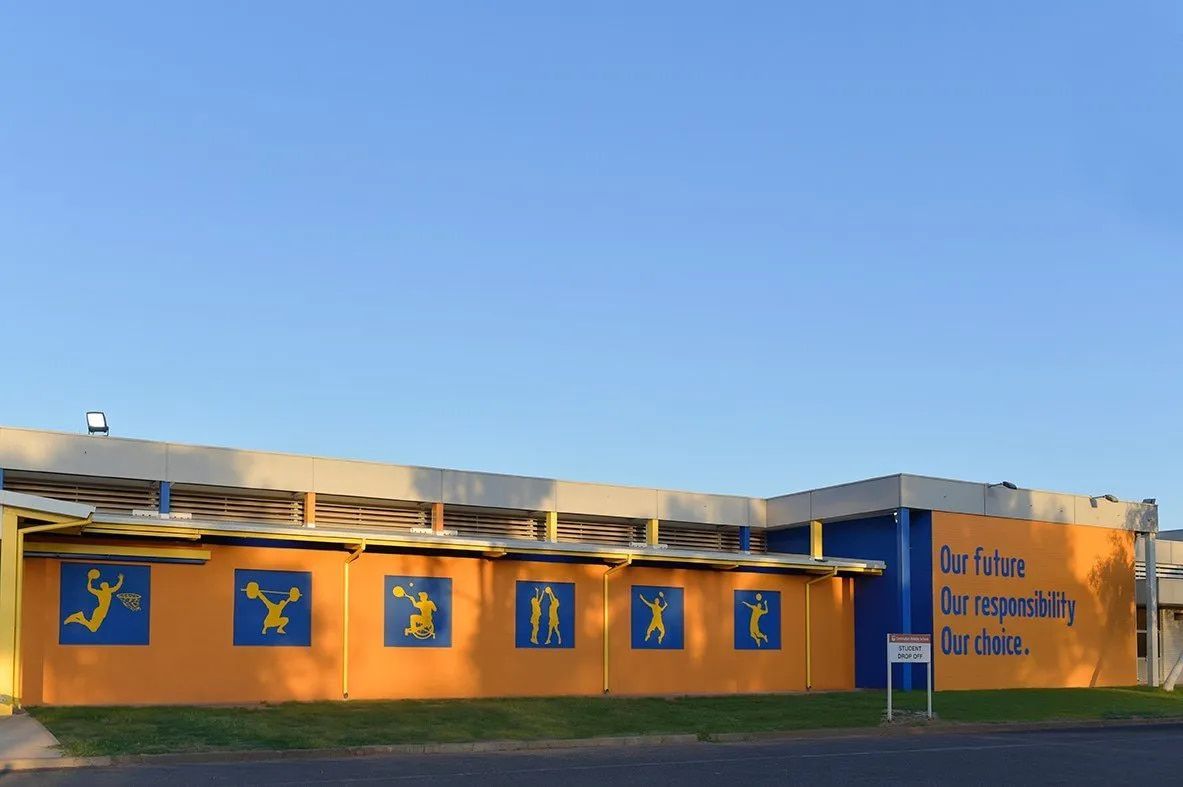 A Yellow and Blue Building With a Sign That Says Do Nothing  — NHM Painting & Projects in Ciccone, NT