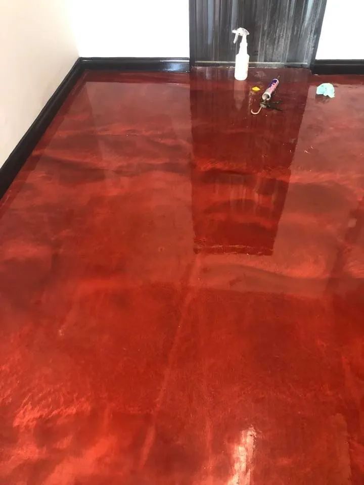 A Red Metallic Floor With a Spray Bottle and Keys on It  — NHM Painting & Projects in Ciccone, NT