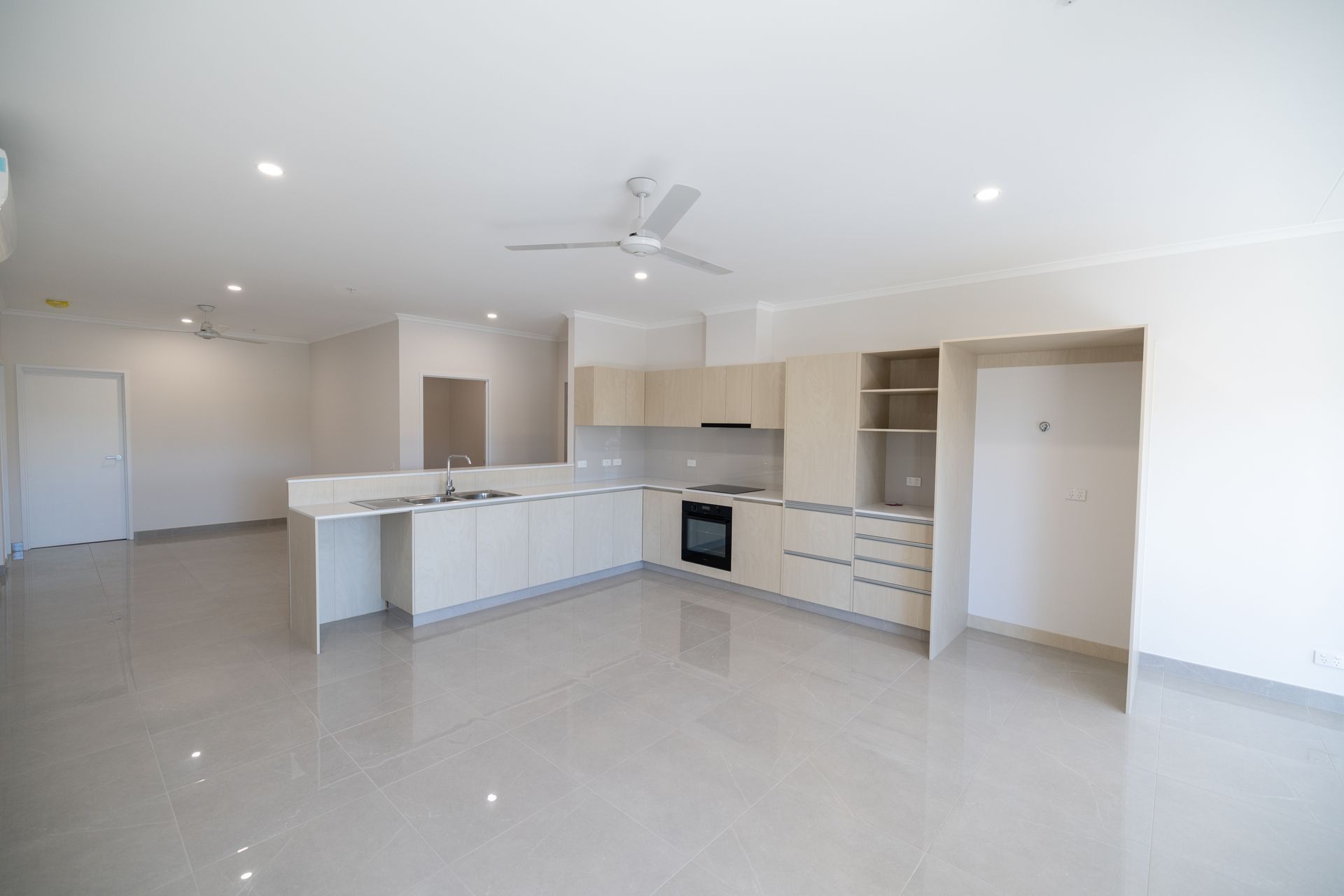 An Empty Kitchen With White Cabinets and a Ceiling Fan  — NHM Painting & Projects in Ciccone, NT