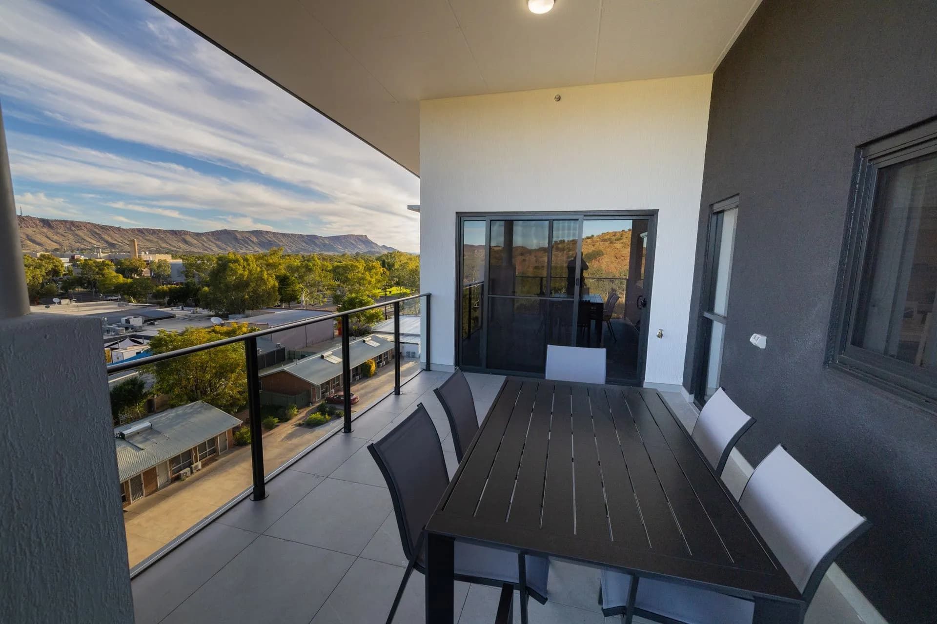A Balcony With a Table and Chairs and a View of a City  — NHM Painting & Projects in Ciccone, NT