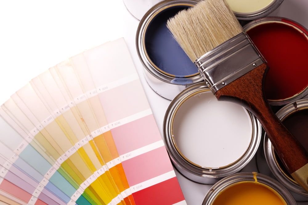 Cans of Paint and a Brush Next to a Palette of Colors — NHM Painting & Projects in Ciccone, NT