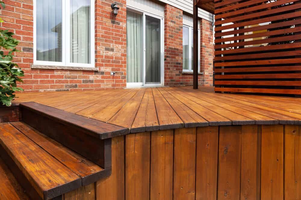 A Wooden Deck With Stairs and a Brick House in the Background — NHM Painting & Projects in Ciccone, NT
