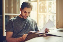 A man is sitting at a table reading a book.