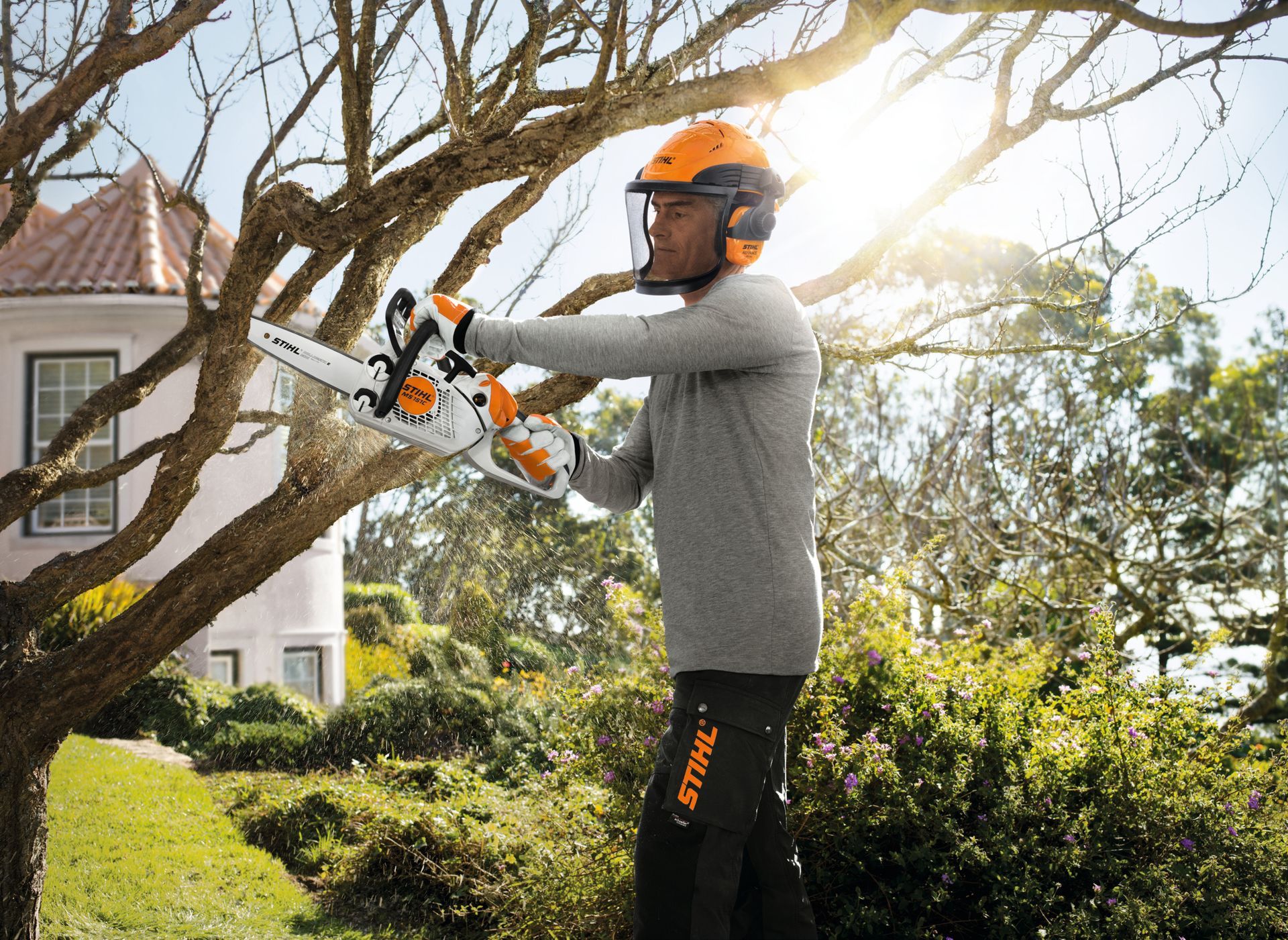 Homme coupant du bois avec une tronçonneuse Stihl 