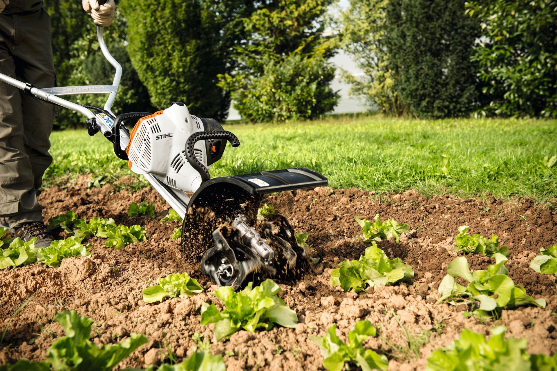 Personne en train de labourer la terre en utilisant une motobineuse