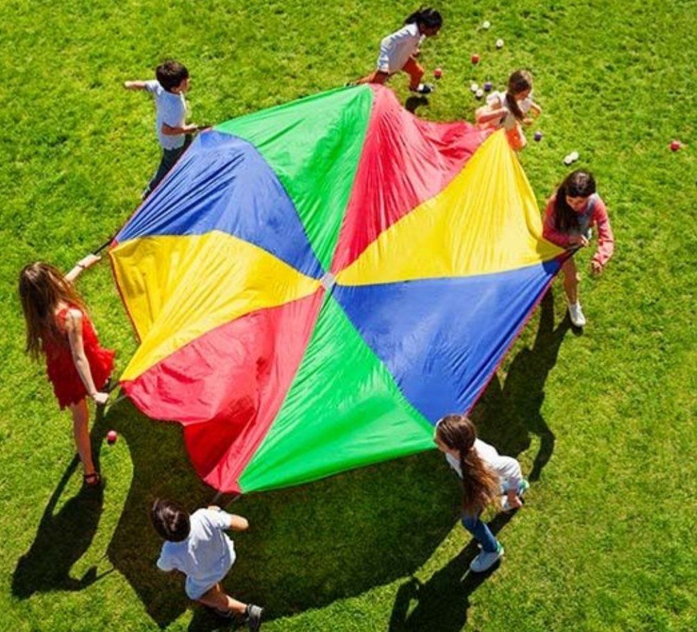 Niños jugando con tela de colores