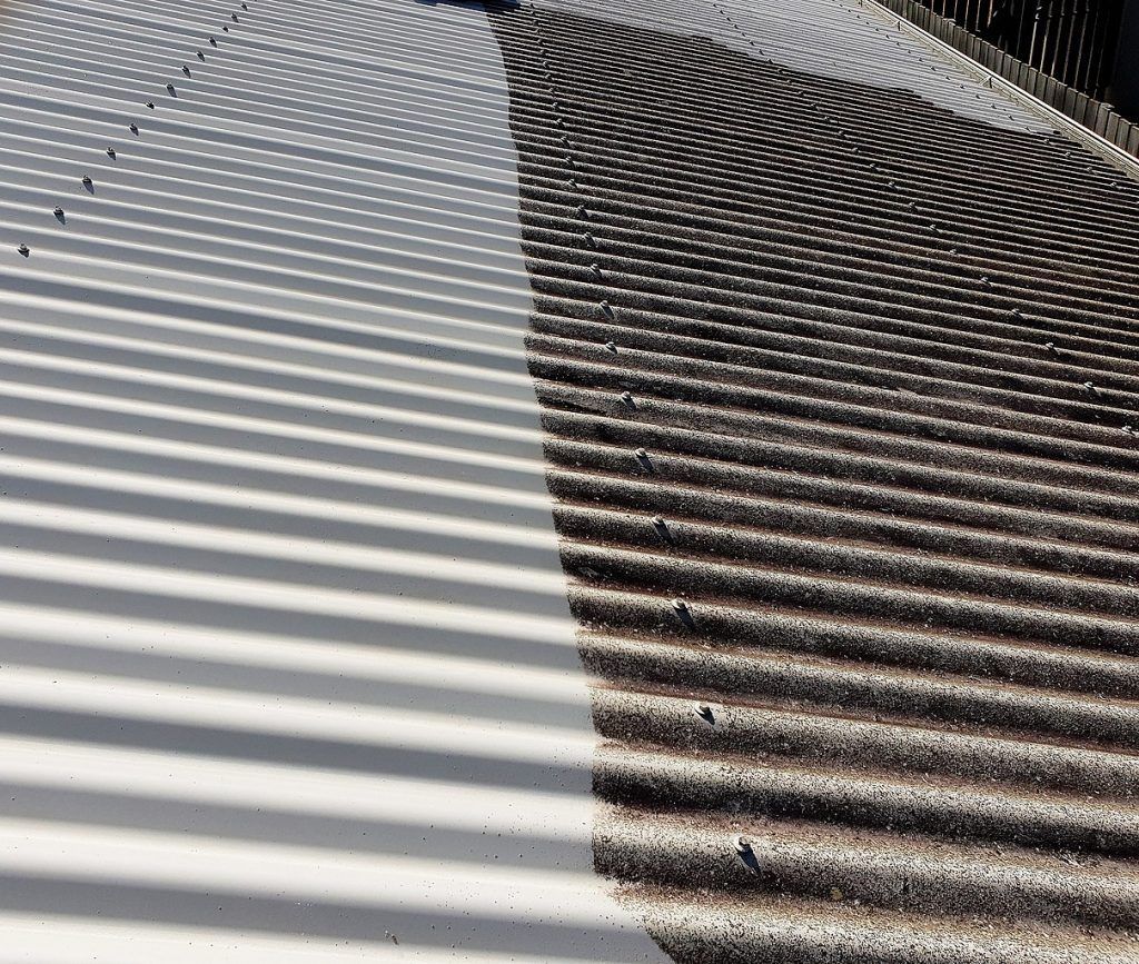 Diagonal striped shadows on a light surface beside a darker gravel path