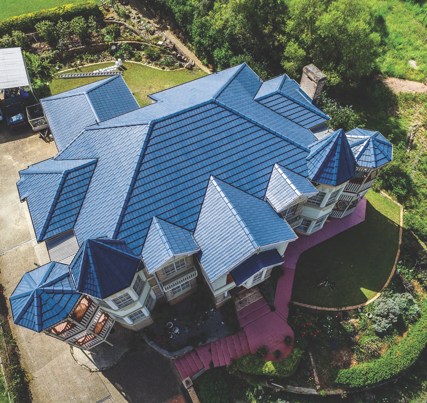 Aerial view of a house with a red roof and rooftop solar panels.