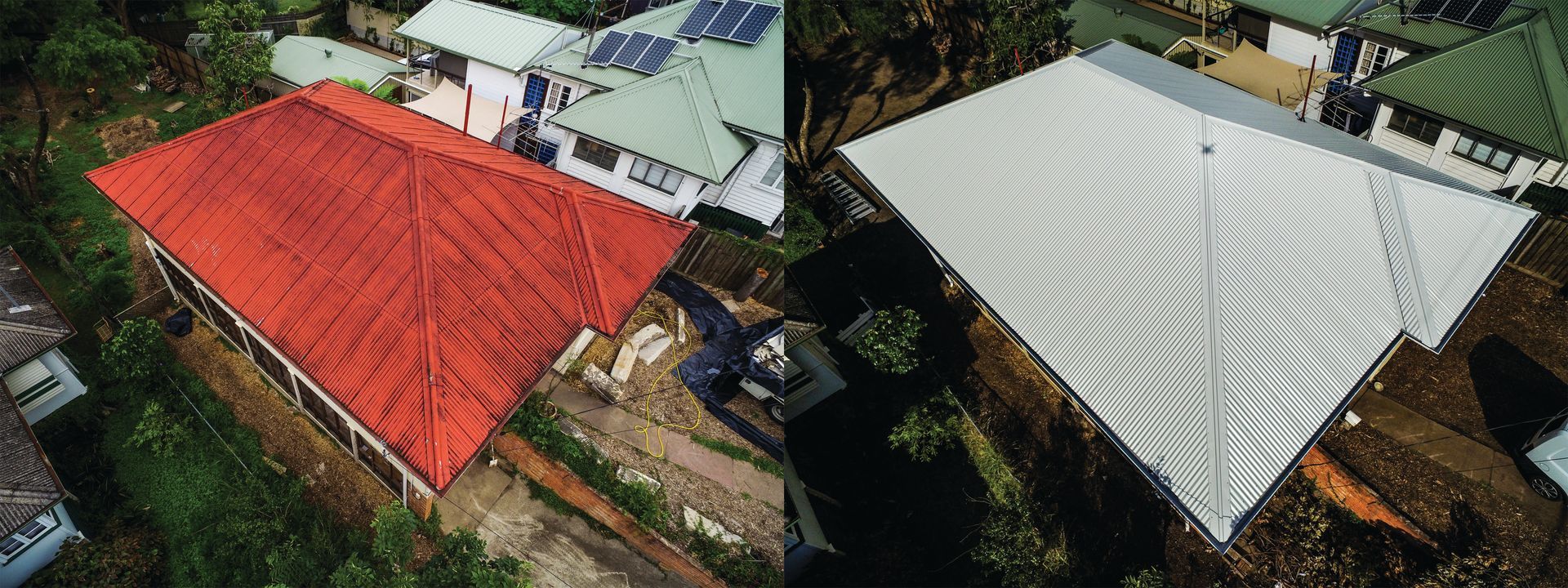 Aerial view of two adjacent houses with red and white metal roofs beside greenery.