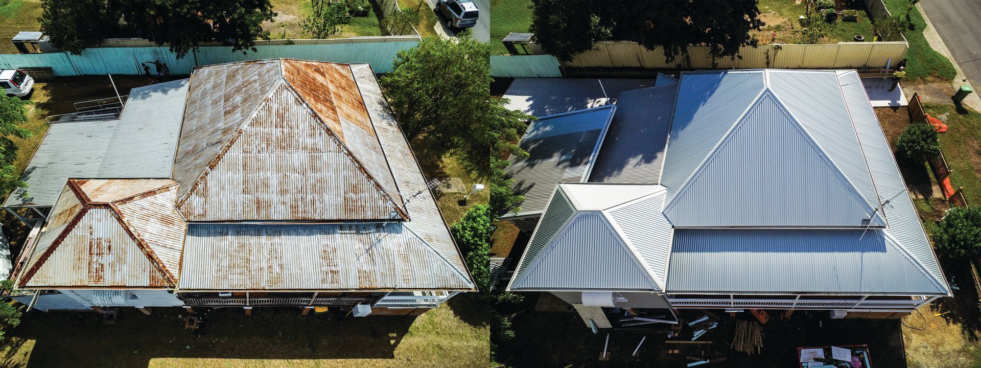 Two neighboring houses with metal roofs, one weathered and one silver, beside trees and a road.