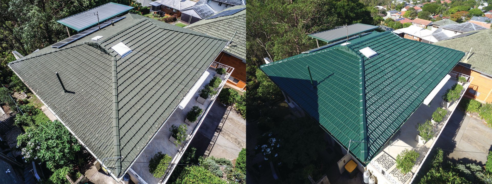 Aerial view of two houses with green roofs surrounded by trees and a driveway