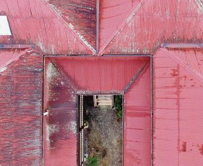 Aerial view of red-tiled rooftops surrounding a narrow courtyard entrance.
