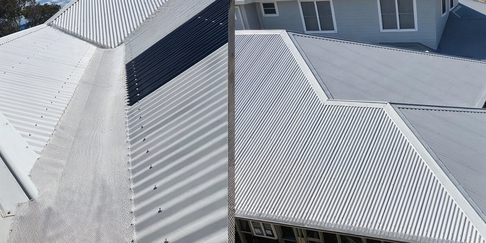 White corrugated metal roofs with a dark rectangular skylight in an aerial view