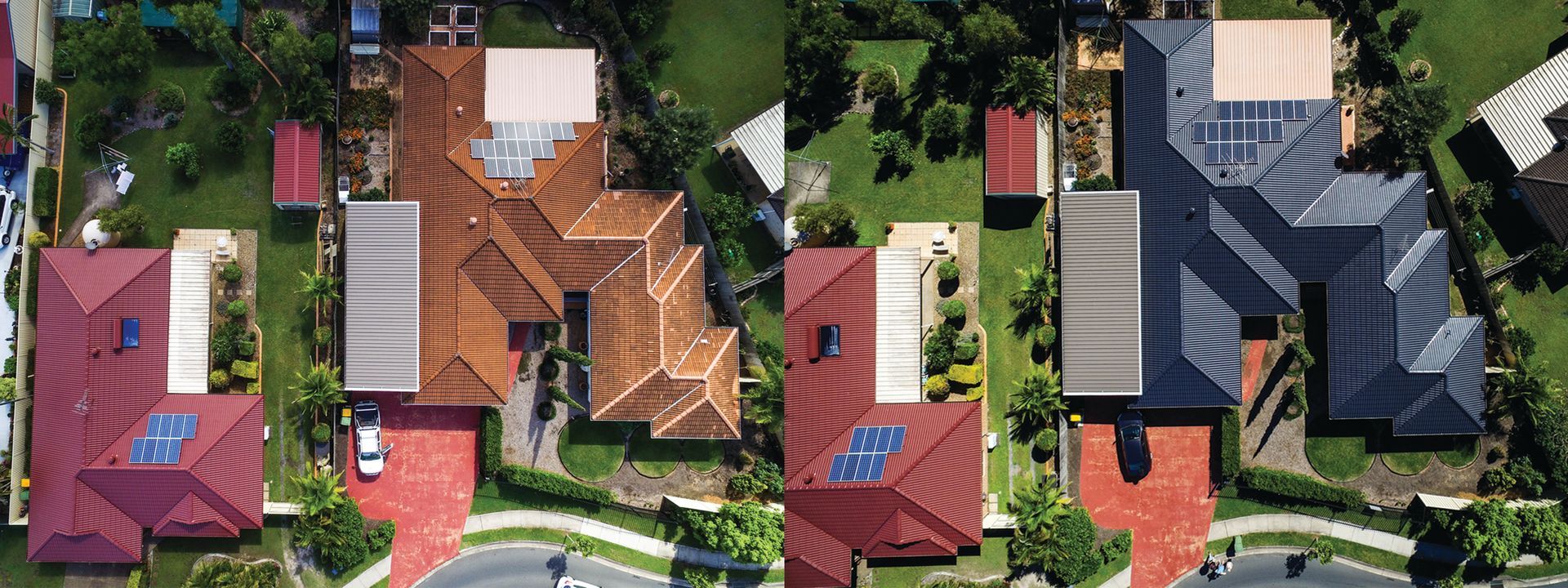 Aerial view of colorful suburban houses with red roofs and green trees along a street