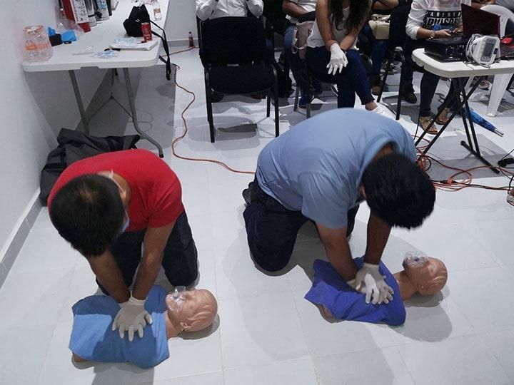 Un grupo de personas practica con un maniquí.