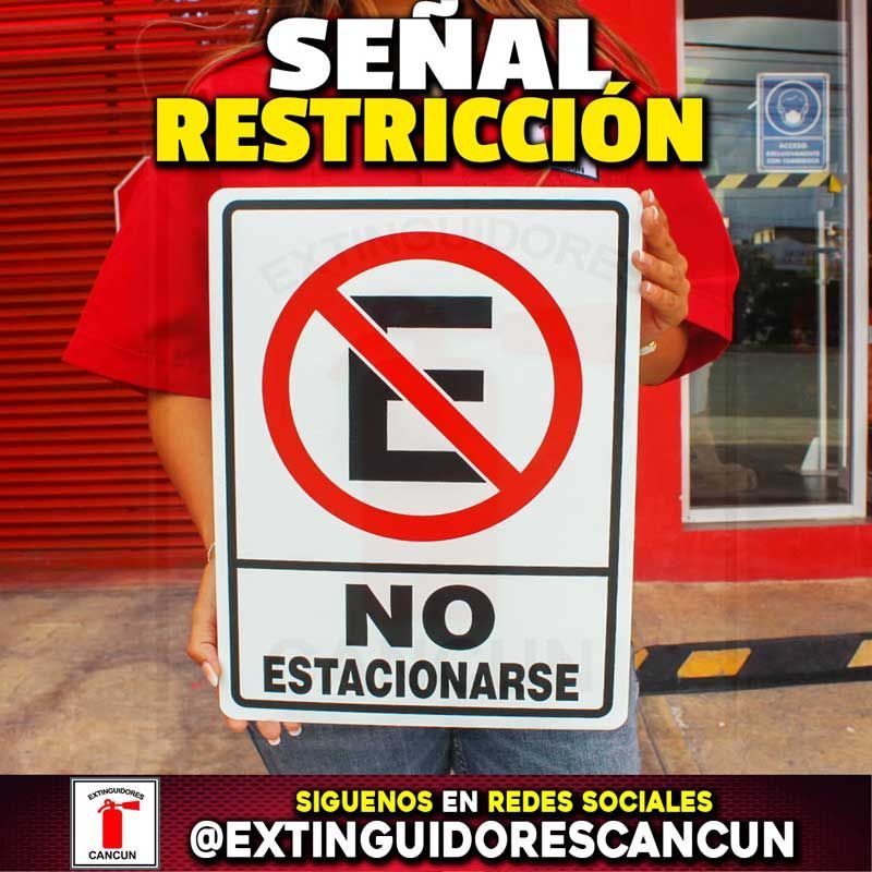 Una persona sostiene un cartel que dice no estacionar.